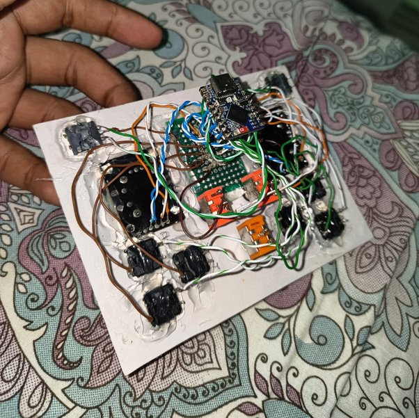 Underside of the remote: ESP32-S3-Zero, two gimbal bases, and a nest of soldered wire held with hot glue